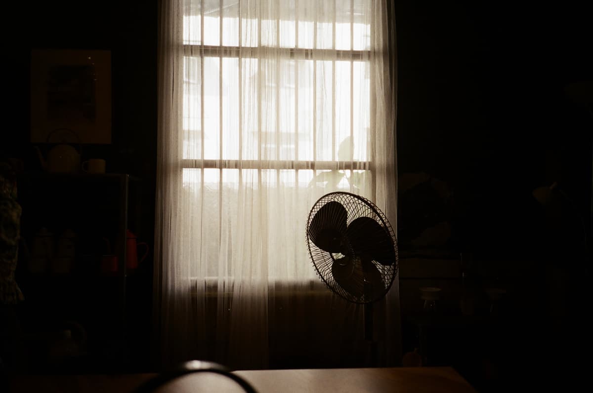 Solitude in Stillness: A Study of Table, Fan, Curtain, and Window